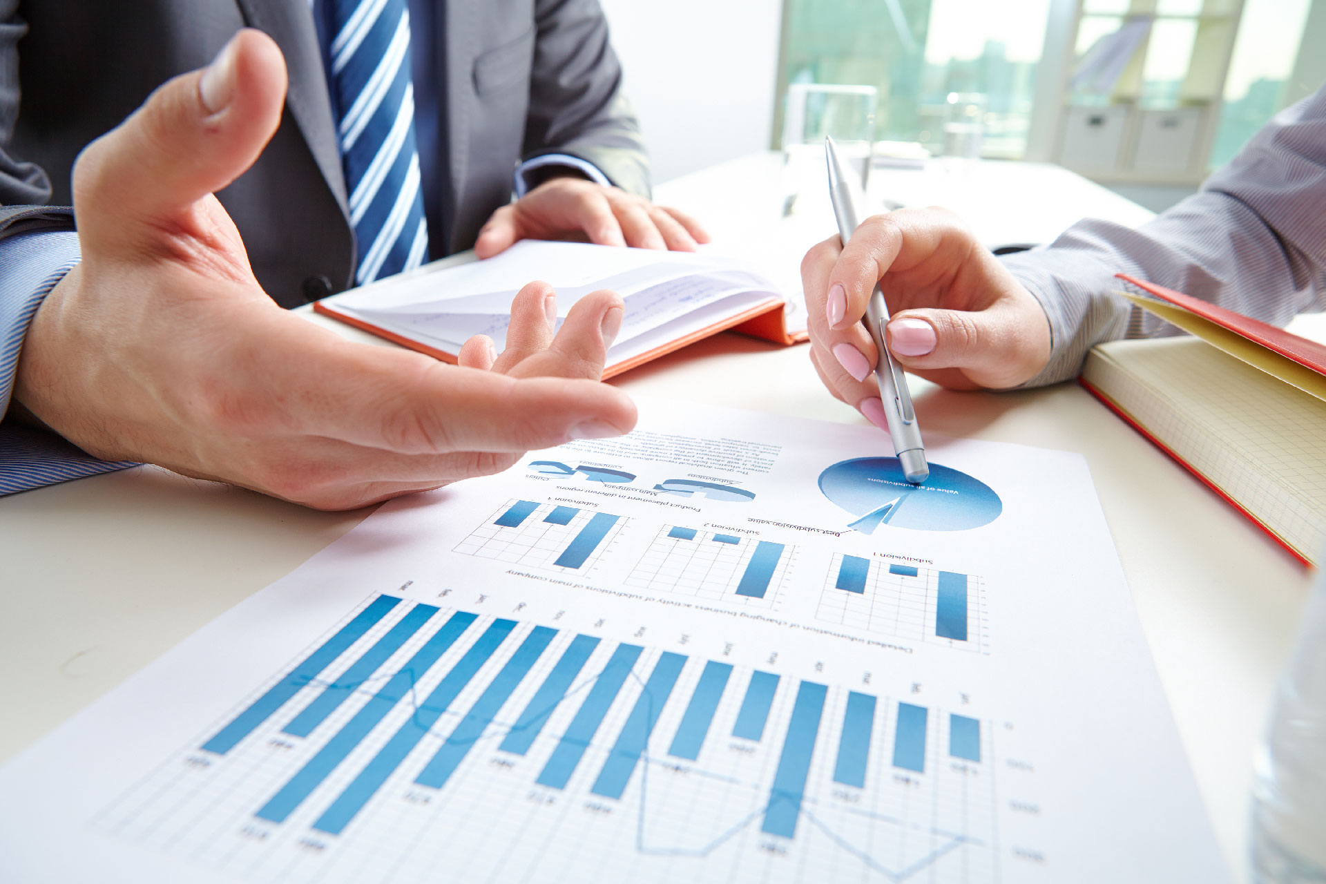 Hands reviewing a printed report with charts