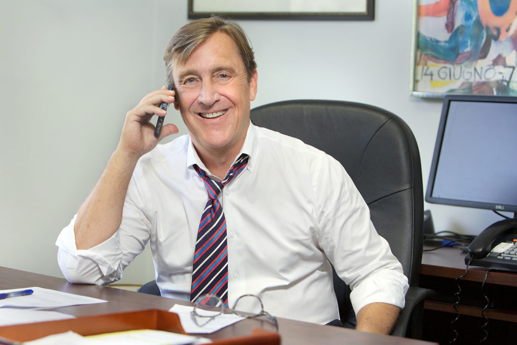John Caine on a call at his desk