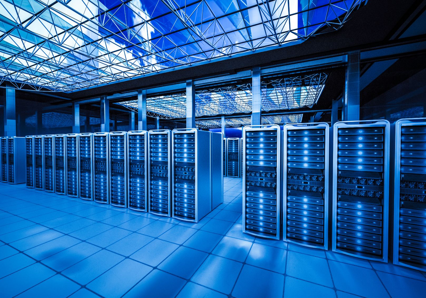 Rows of servers in a data center hall under a glass roof